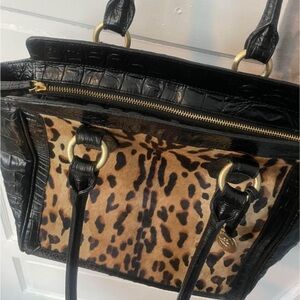 The bag is leopard print calf hair on the front. Black embossed leather on rest